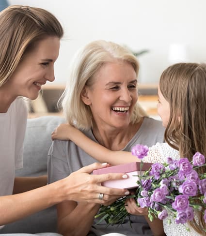 Happy Grandma Receiving Flowers From Grand Daughter - Financial advisers In Whitsundays, QLD